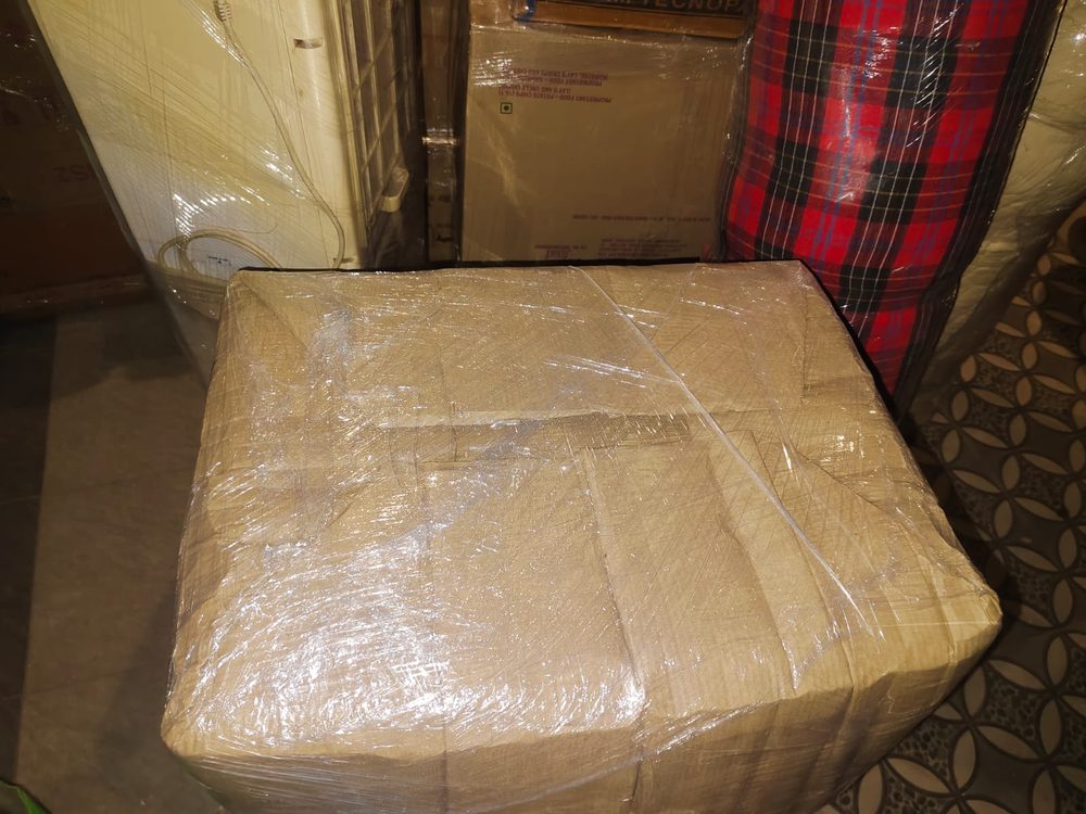 Cushioned furniture piece wrapped and secured for transit